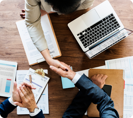Imagem de mãos sendo apertadas em um ambiente de escritório